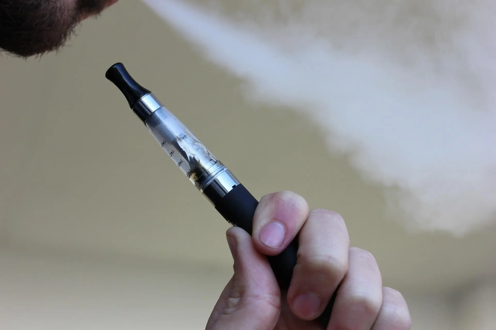 man blowing out a vape cloud