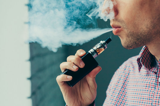 Sub ohm quality shown by an image showing man using vape and blowing smoke.