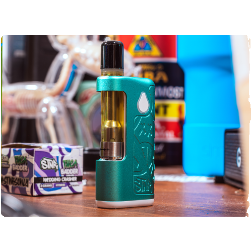 Sub ohm cart shown in front of a colorful background on top of a wooden table.