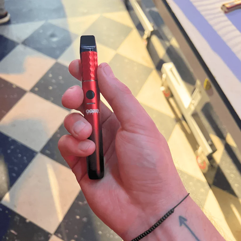 The extract vaporizer being displayed in front of a colorful background.