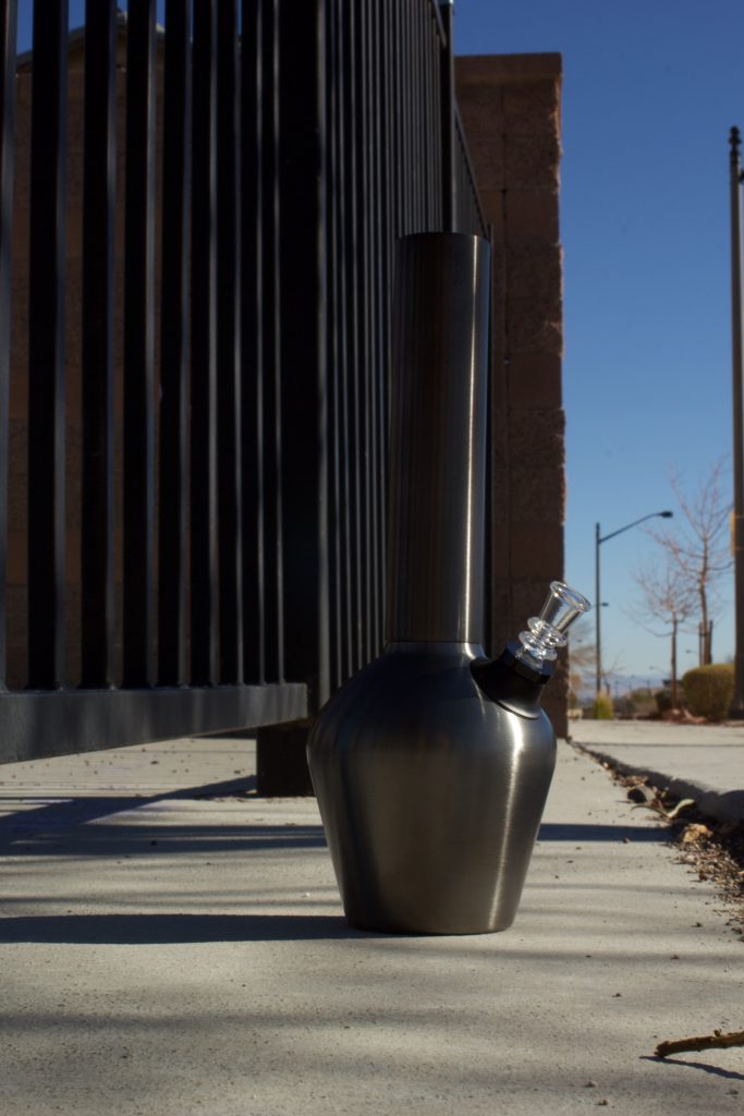 Gunmetal bongs displayed along a road during the day.