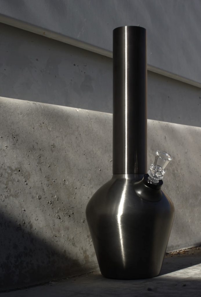 Gunmetal bongs displayed along a road during the day.