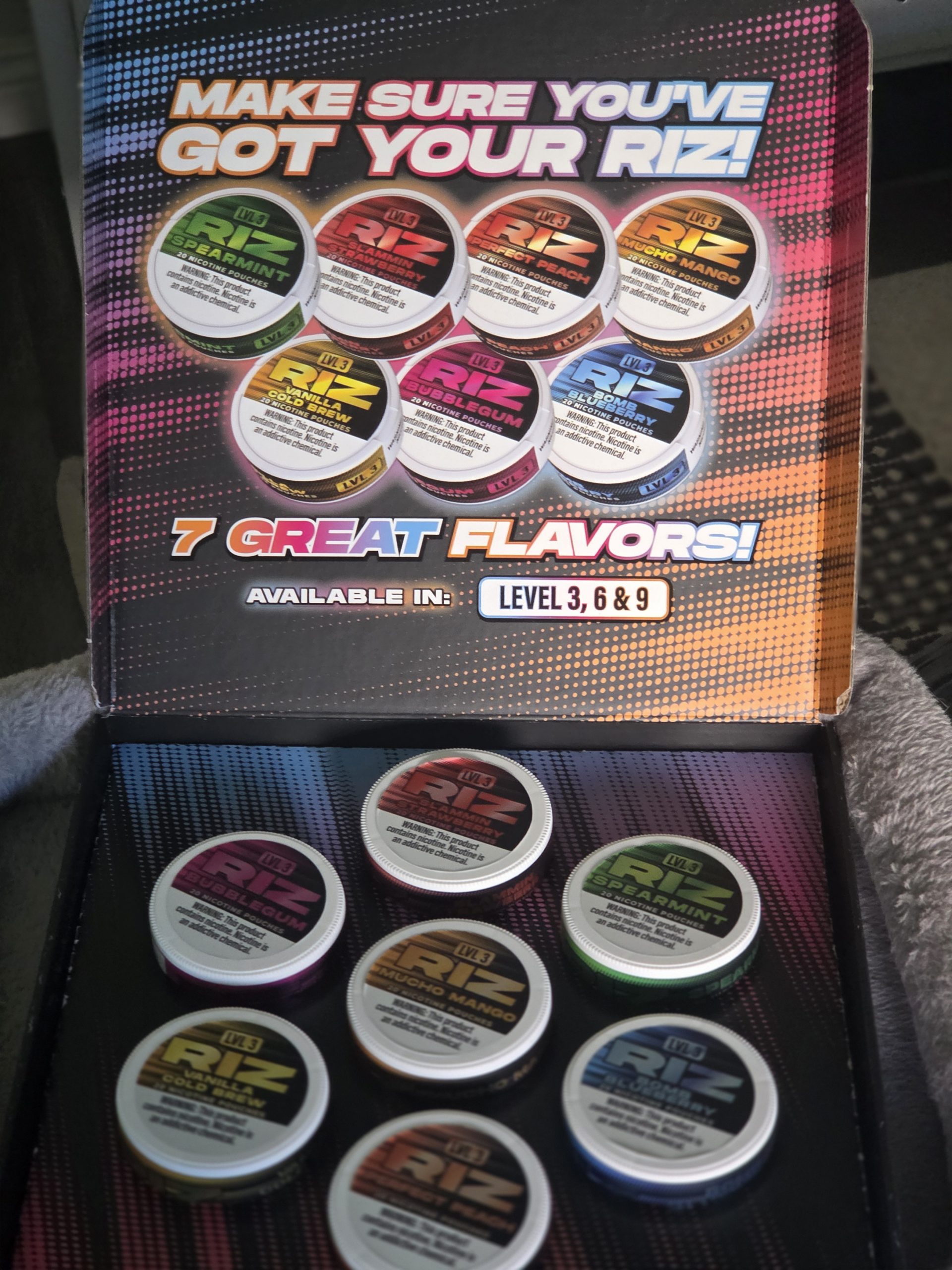 Riz Nic Nicotine Pouches displayed in a package box on top of a soft pillow.