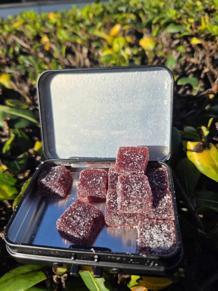 10DC Double Blackberry Lemonade Live Resin Gummies displayed on a grass patch under the sunlight.