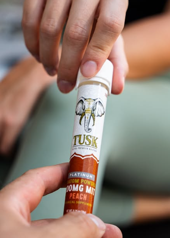 Two people reaching out with the best kratom liquid shots to one another.