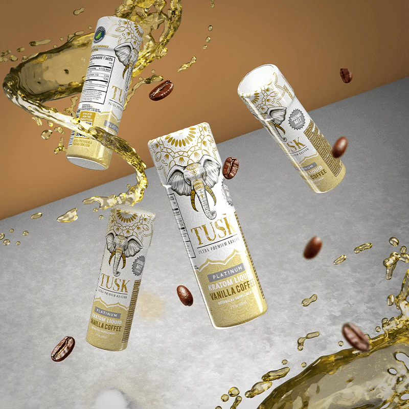 Four kratom shots displayed in front of a white and gold background with liquid splashing below and coffee beans flying.