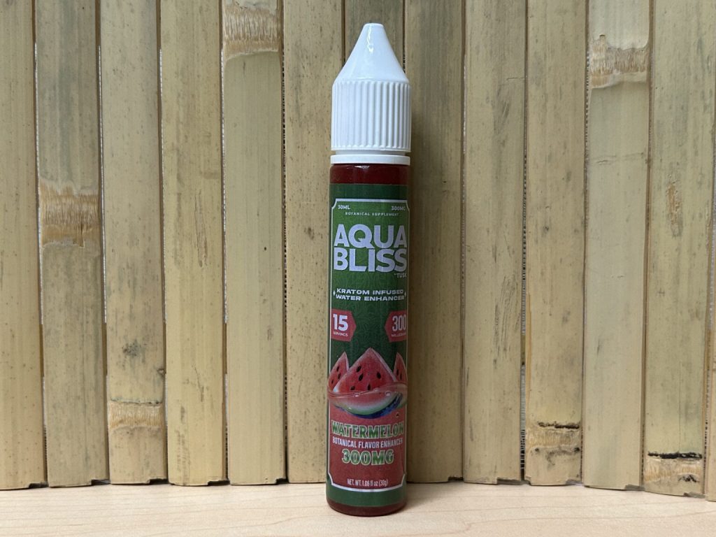 A single kratom water enhancer from Tusk Kratom Aqua Bliss displayed in front of a wooden wall.