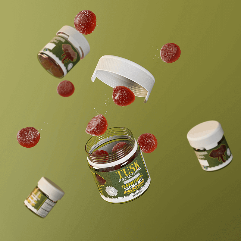 Kratom interactions depicted by Tusk Kratom Gummies floating in the air with red gummies floating too in front of a green background.