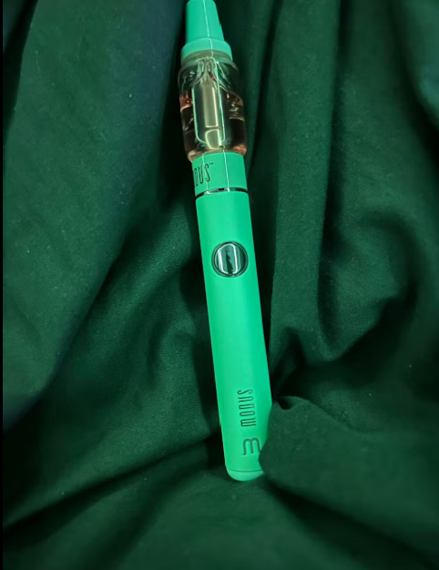 Green Modus Brand XL 510 Battery device displayed with a green sheet of cloth behind it as background.