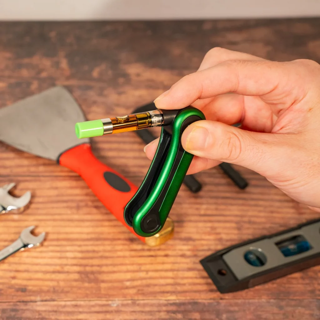 Hinge Flick 510 Thread Battery – 210 mAh – Green Drip displayed being held by a person to show different sides of it.