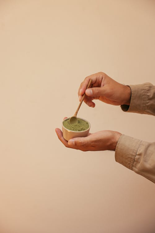 Kratom for focus being mixed by someone in a cup using a stirrer.