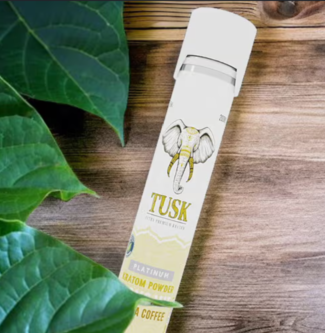 Kratom vs CBD shown by a Tusk Kratom product placed beside a set of leaves on top of a wooden table.