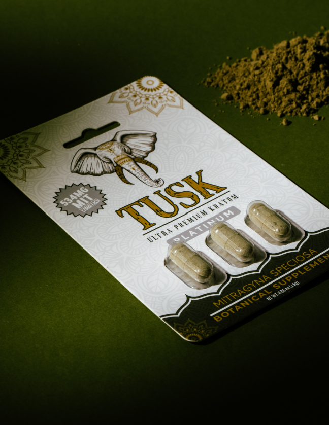 Kratom vs CBD shown by a Tusk Kratom powder capsules pack in a green background with powder beside it.