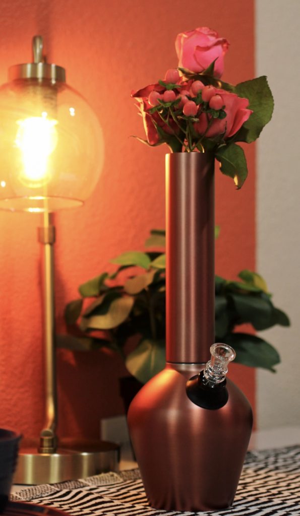 Aesthetic bong by Chill Steel Pipes displayed inside an aesthetic bathroom on a sink with flowers and roses.