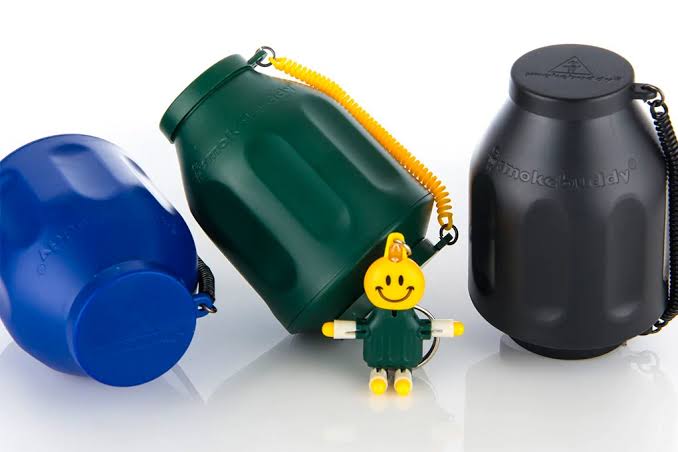 Best odor eliminator for smoke displayed in threes in front of a white background with a Smokebuddy toy in front of them.