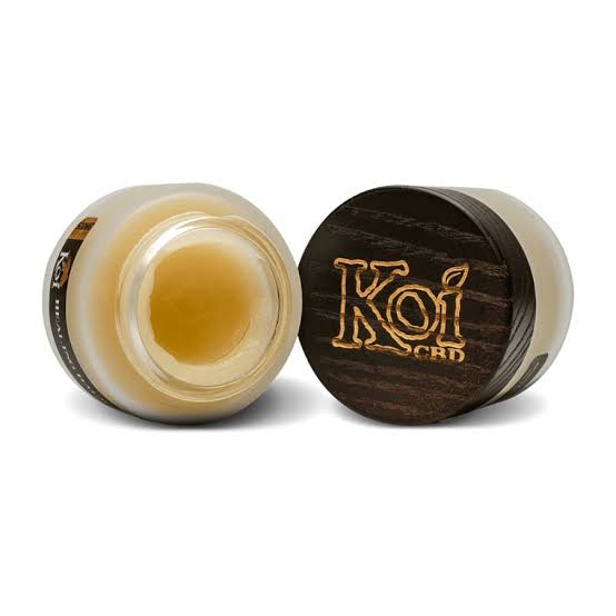 CBD balms from Koi showing two jars, one that is open showing the gel, and one that is closed showing the black cover with "Koi" on it.