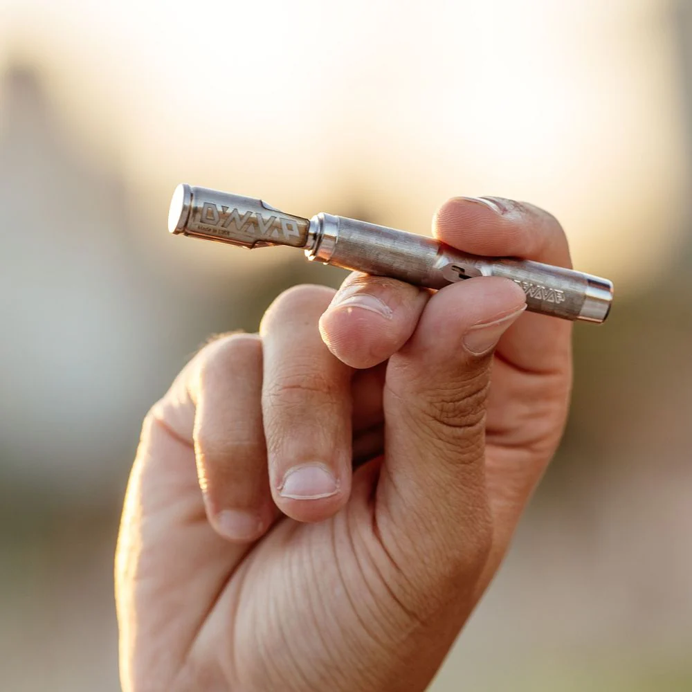 Dry herb vaporizer for beginners held by someone in an outdoor background.